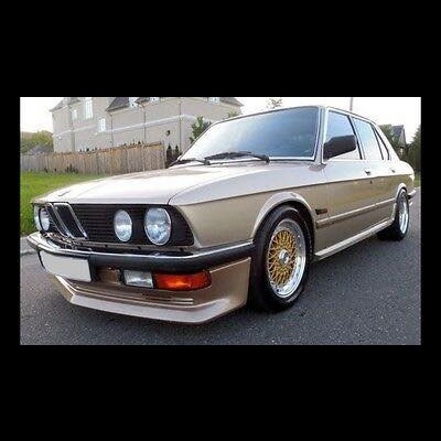 Carro clássico bege com jantes douradas e faróis redondos