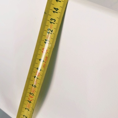 Fita métrica amarela sobre superfície branca lisa