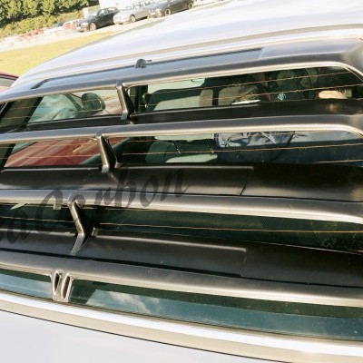 Caçadeiras traseiras pretas em plástico e vidro fumado num carro branco