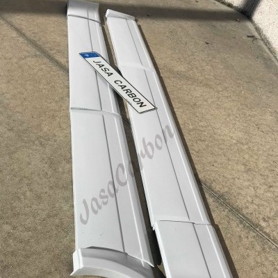 Par de frisos brancos com etiqueta JASA CARBON no chão perto da parede