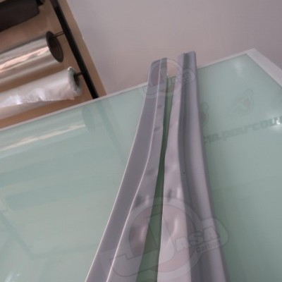 Par de peças de plástico cinza claro sobre superfície de vidro com logótipo JASH na parede