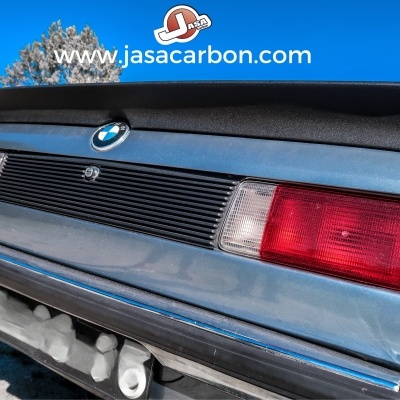 Parte traseira de um carro BMW azul com spoiler preto e luzes traseiras vermelhas.