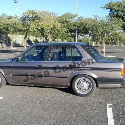 Automóvel clássico cinza escuro estacionado num parque aberto