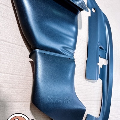 Peças pretas de plástico ou fibra de carbono com acabamento liso, sobre superfície de cartão