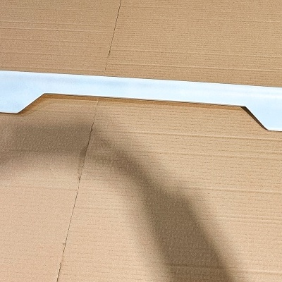 Peça longa branca de plástico sobre superfície de madeira clara