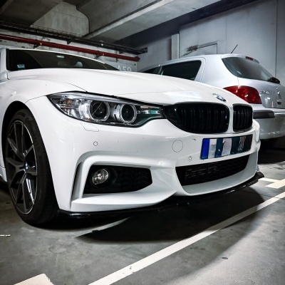 BMW branco estacionado em parque de estacionamento subterrâneo ao lado de carro prata