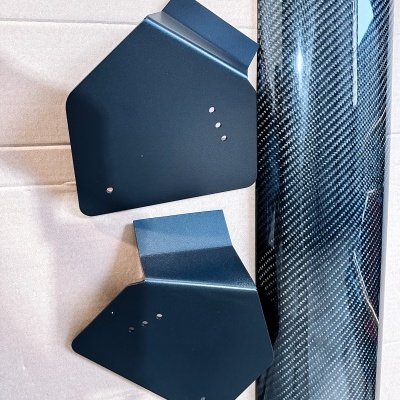 Suportes metálicos pretos e cilindro com padrão de fibra de carbono