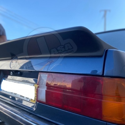 Parte traseira de um carro azul com farol traseiro vermelho e laranja, e spoiler preto