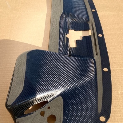 Peça em fibra de carbono azul escuro com recortes sobre fundo claro e texto www.jasacarbon.com