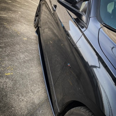 Carro desportivo preto visto de lado com jantes cinza escuro e pinças de travão vermelhas