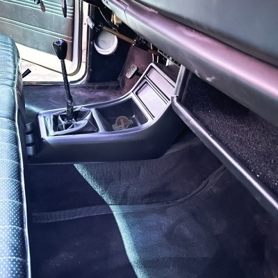 Interior de carro com alavanca manual, bancos azuis e consola central preta