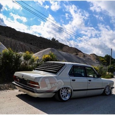 Carro sedan branco estacionado numa estrada rural