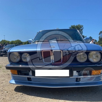 Frente de carro clássico BMW azul com faróis redondos duplos ao ar livre