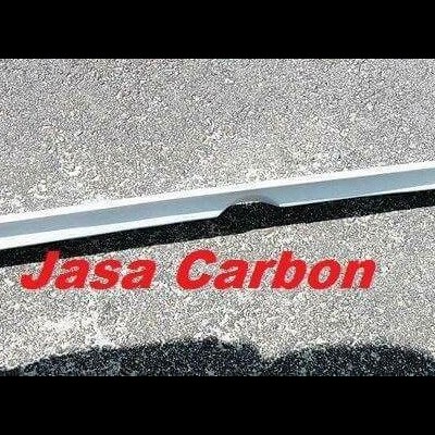 Barra decorativa automóvel branca sobre pavimento cinzento com texto vermelho Jasa Carbon