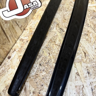 Dois acabamentos pretos brilhantes sobre madeira com logotipo JASA Carbon