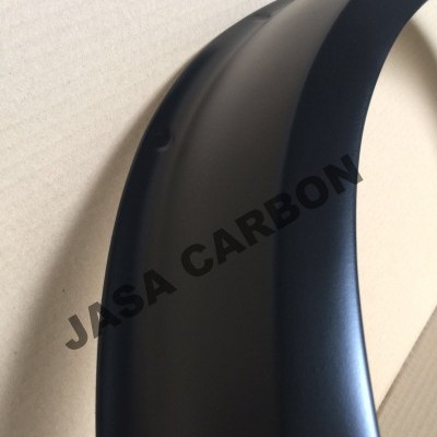 Peça curva preta fosca com texto JASA CARBON sobre uma superfície clara