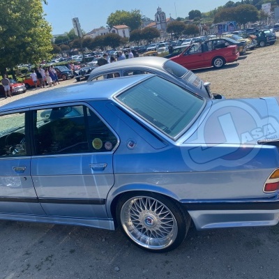 Carro azul clássico com jantes de liga leve num parque ao ar livre