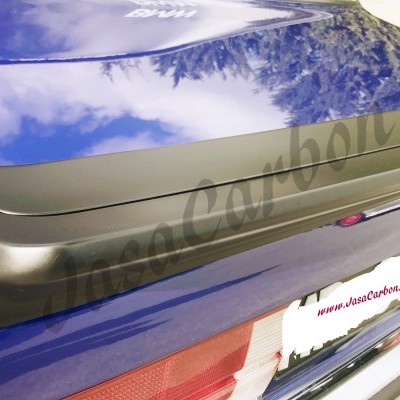 Spoiler traseiro em carbono preto fosco numa mala traseira azul brilhante de carro.