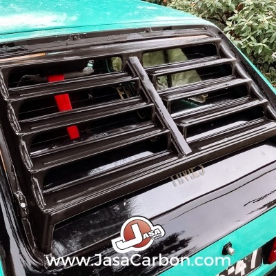 Carro verde água com grelha preta em persianas na janela traseira e logótipo Jasa Carbon.