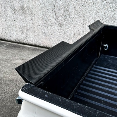 Caixa traseira de carrinha branca com proteção antidanos preta e parede cinzenta ao fundo