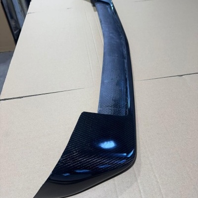 Ailerão traseiro de fibra de carbono preta sobre superfície de cartão