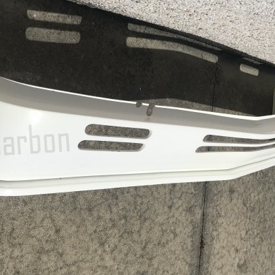 Peça branca com texto Jasa Carbon e padrão de fibra preta sobre chão cinza