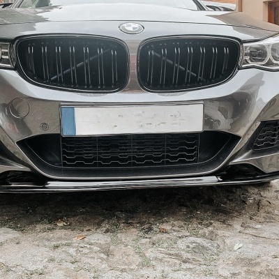 Frente de um carro BMW cinzento metálico com grelha preta e spoiler preto