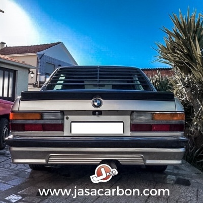 Traseira de carro BMW cinzento estacionado ao ar livre com texto www.jasacarbon.com no pavimento