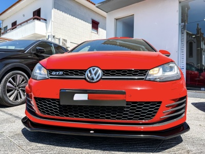 Carro Volkswagen GTD vermelho estacionado junto a edifício branco