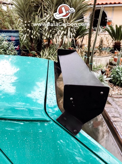 Asa traseira preta num carro verde com gotas de água e logo Jasa