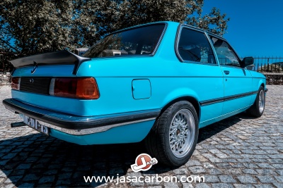 Carro BMW clássico azul turquesa coupé duas portas com spoiler traseiro preto e jantes prata