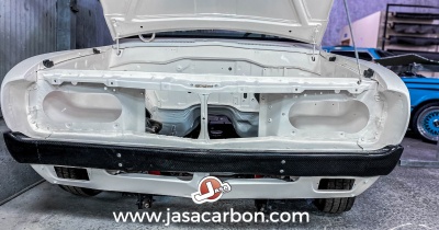 Parte dianteira de carro branco sem faróis, para-choques preto, logótipo Jasacarbon no chão