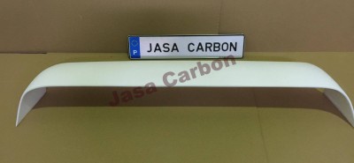 Spoiler traseiro branco com texto JASA CARBON numa placa atrás, colocado sobre superfície castanha