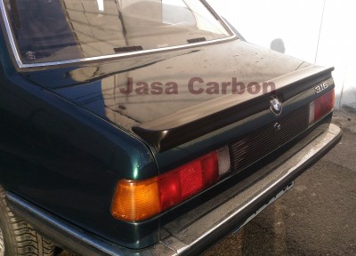 Traseira de carro BMW verde escuro com spoiler preto e farol vermelho e âmbar