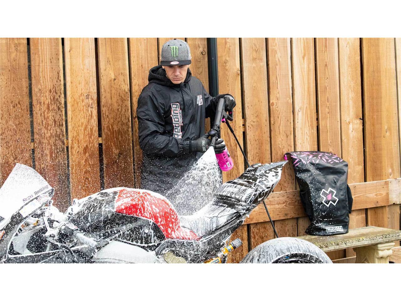 Kit MUC-OFF de máquina de lavar a pressão Homem a lavar mota desportiva branca e vermelha com mangueira de pressão