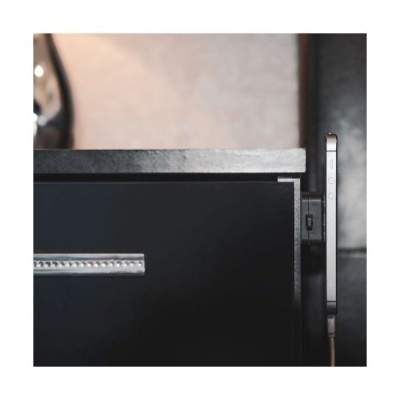 Gaveta preta com alça metálica e telemóvel preso ao lado direito