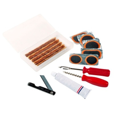 Kit de reparação de pneus com fitas, remendos e ferramentas sobre fundo branco