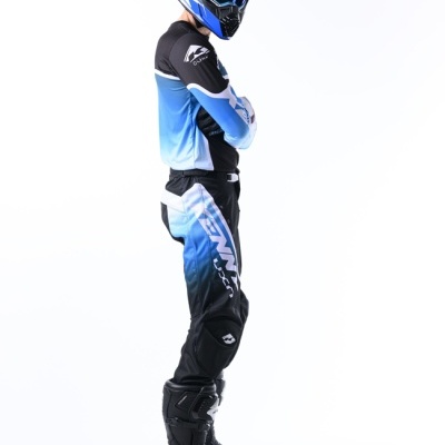 Homem com equipamento de motocross azul, preto e branco de perfil