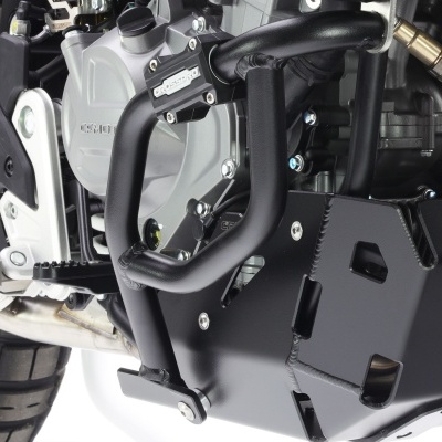 Motor de motocicleta com proteção metálica preta e estrutura cinza em fundo branco