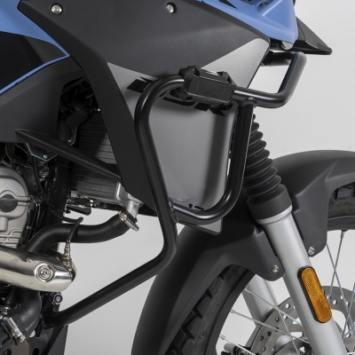 Detalhe de moto azul e preta com proteção metálica e suspensão dianteira