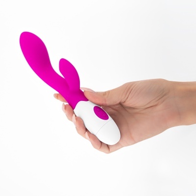 Vibrador rosa com botão branco, mãos segurando, fundo branco