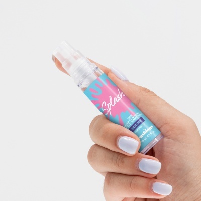 Frasco de spray Splash com rótulo azul e rosa na mão