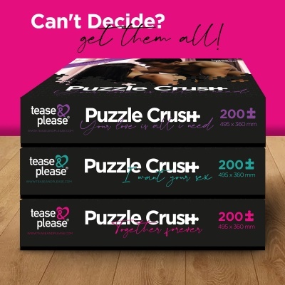 Três caixas de puzzles 'Puzzle Crush' empilhadas sobre chão de madeira com fundo rosa