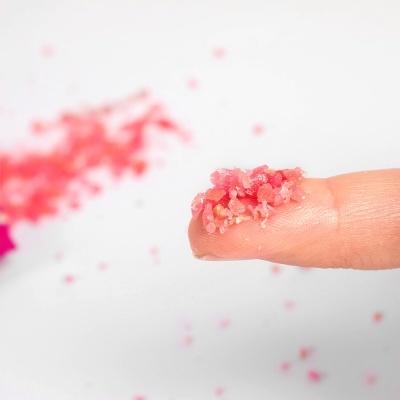 Dedo com pequenos cristais cor-de-rosa colados à ponta