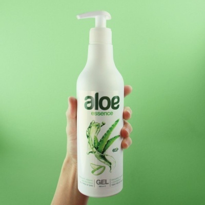 Frasco branco com doseador e rótulo com aloe essence em fundo verde