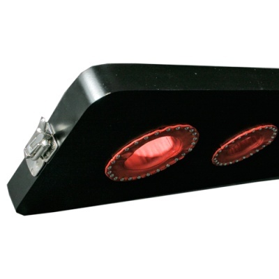 Produto preto em forma trapézio com duas lentes vermelhas e fivela metálica