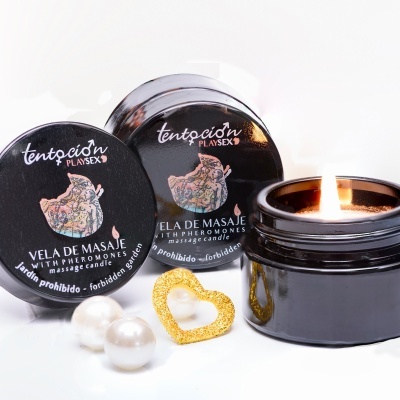 Vela de massagem preta com tampa, pérolas brancas e anel dourado em fundo branco