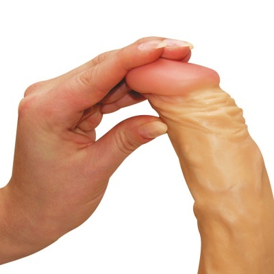 Mão a segurar e dobrar objeto em forma de falo cor bege com ponta rosada