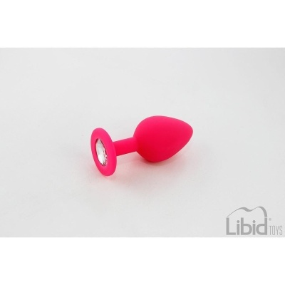 Plug anal rosa em silicone com pedra transparente na base sobre fundo branco