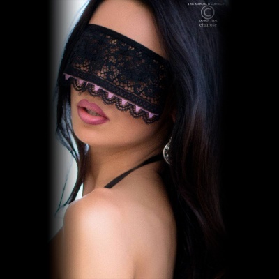Mulher com venda preta de renda nos olhos e cabelo escuro